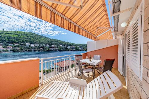 a balcony with a table and chairs and a view of the water at Apartments Vesna in Brna