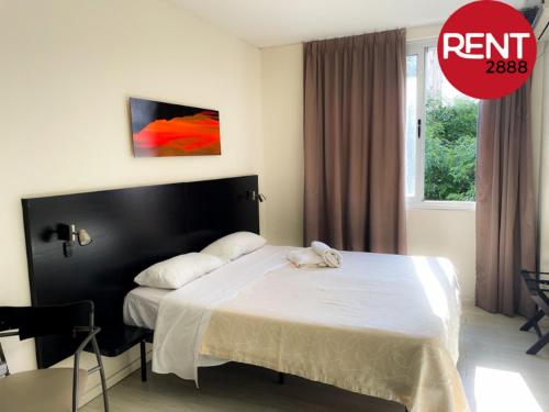 a bedroom with a bed with a white bedspread and a red circleropherophe at Rent Perón Italiano in Buenos Aires