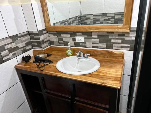 a bathroom counter with a sink and a mirror at Cabaña Rincón de Cielo in Santa Fe