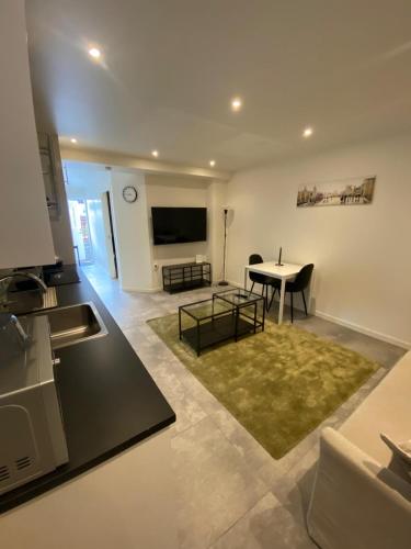 a kitchen and a living room with a table and a television at Noah Longstay Apartment in Västerås