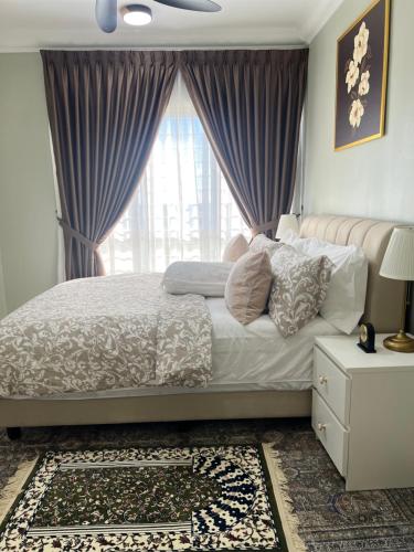 a bedroom with a bed with purple curtains and a window at Amliza homestay in Cyberjaya