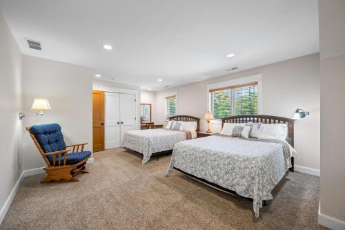 a bedroom with two beds and a chair at Big Sky Cabin in Nashville