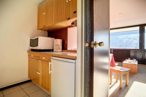 une cuisine avec un réfrigérateur et un micro-ondes dans l'établissement Résidence Aravis - Appartement lumineux & spacieux · Ski aux pieds · Balcon MAE-3464, aux Menuires