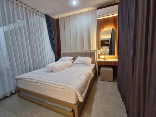 a bedroom with a bed and a sink and a mirror at Batu Hilltop Villa in Batu