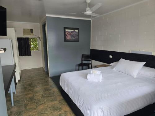 a bedroom with a large white bed with a pillow at Kalka Palms Hotel Motel in Rockhampton