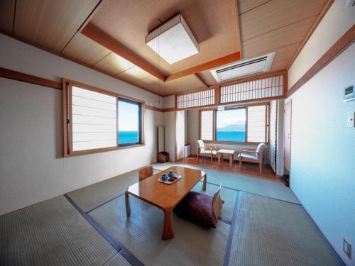 a living room with a table and some windows at REBUN Hotel SARYO in Kafuka