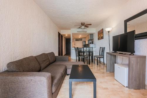 a living room with a couch and a flat screen tv at Cancún Suites Apartments - Hotel Zone in Cancún
