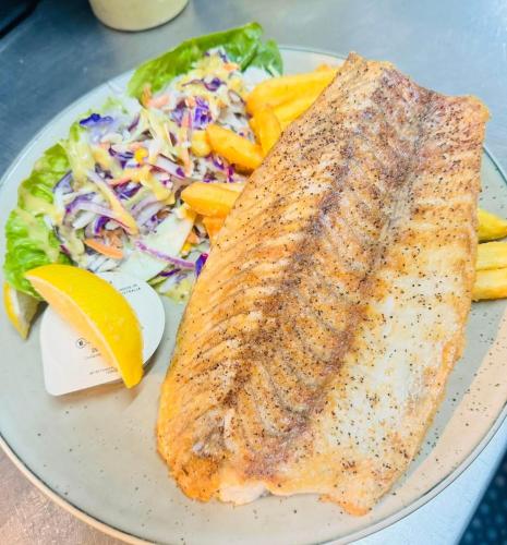 a plate with a fish and a salad and a salad at Queensland Hotel in Goondiwindi