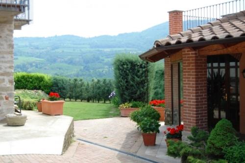 a brick house with a view of a garden at Agriturismo La Costa in Torre Bormida