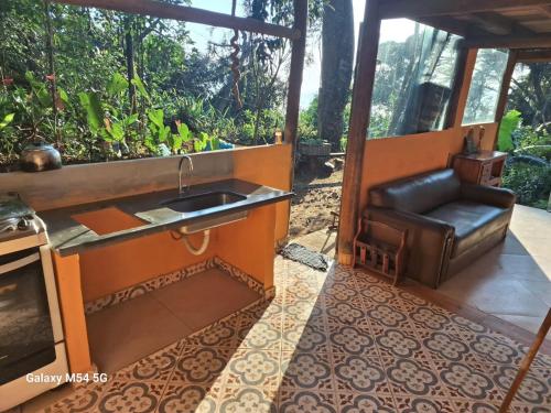 a kitchen with a sink and a leather chair at Chopana Alpina na Praia Brava in Ubatuba