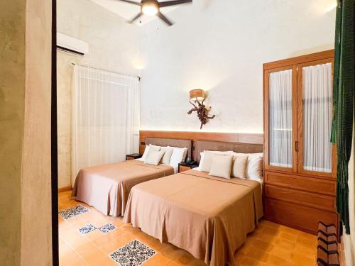 a room with two beds in a room at Ya'ax Hotel Boutique in Mérida