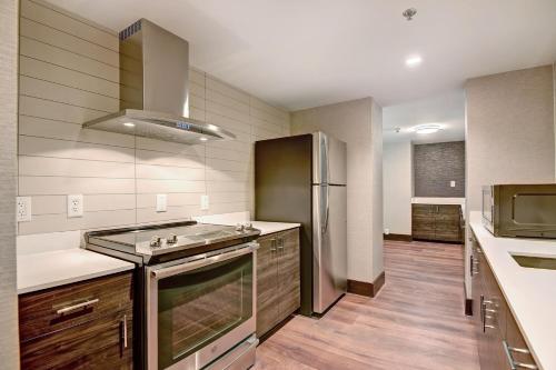 a kitchen with a sink and a refrigerator at Tulsa Marriott Southern Hills in Tulsa