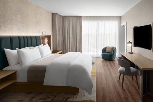 a hotel room with a bed and a desk at The Westin Atlanta Gwinnett in Duluth