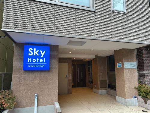 a building with a sky hotel sign on it at SkyHotel Kikukawa 駅徒歩2分 in Tokyo