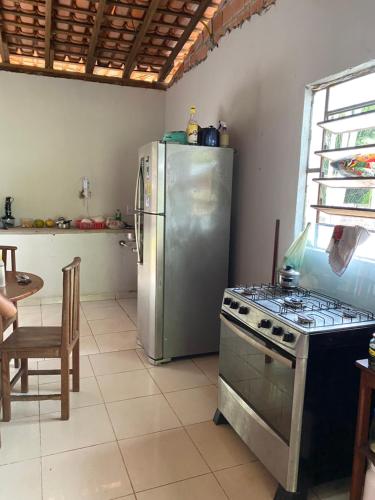 a kitchen with a stainless steel refrigerator and a stove at Casa na floresta cósmica in Ananindeua