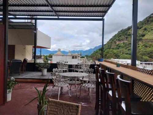 a patio with tables and chairs and mountains in the background at Royal Palace Hostal in Panajachel