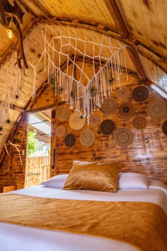 ein Schlafzimmer mit einem Bett, an dessen Decke Münzen hängen in der Unterkunft Glamping CAVE in Isnos