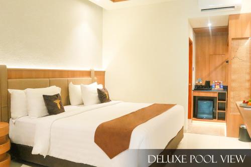 a bedroom with a large white bed with a fireplace at Grand Palma Pangandaran by Horison in Pangandaran