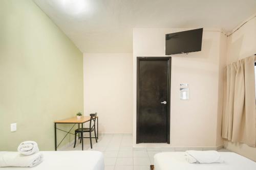 a room with two beds and a black door at Hotel Quiam in Playa del Carmen