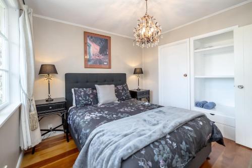 a bedroom with a bed and a chandelier at Bronte House in Martinborough 