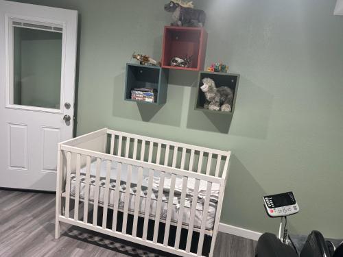 a baby room with a crib and shelves on the wall at Garden Suite Two Bedroom with Hot Tub Sauna Outdoor kitchen and Game Room in Everett