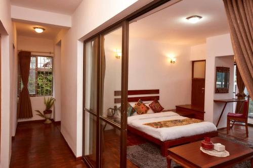 a hotel room with a bed and a table at Ghost Villa Pokhara with mountain view 20mins from main area in Rānīpauwa