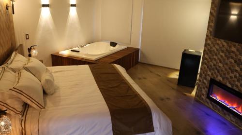 a bedroom with a bed and a bathroom with a fireplace at Hotel Vista Montaña in Villa de Leyva