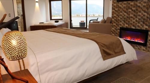 a bedroom with a large bed and a fireplace at Hotel Vista Montaña in Villa de Leyva