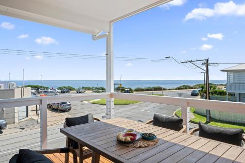 a table on a balcony with a view of the ocean at C-Views - Aldinga Beach - C21 SouthCoast Holidays in Aldinga Beach
