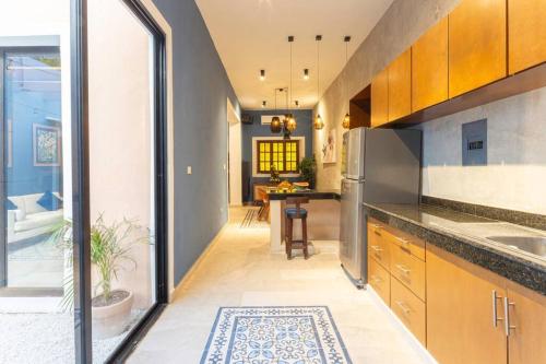 a kitchen with wooden cabinets and a dining room at Casa Mercedes - Stylish & Historic in heart of Mérida in Mérida