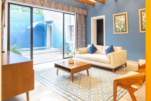 a living room with a couch and a table at Casa Mercedes - Stylish & Historic in heart of Mérida in Mérida