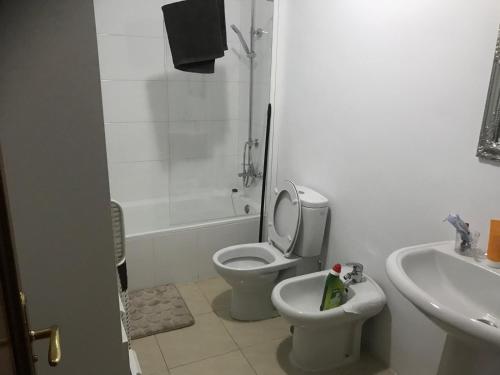 Un baño blanco con inodoro y lavabo. en Playa Paraiso vue océan, en Playa Paraiso