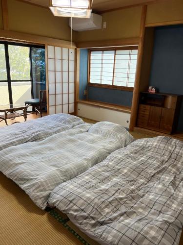 a large bed in a room with a window at I Love Izu in Futo