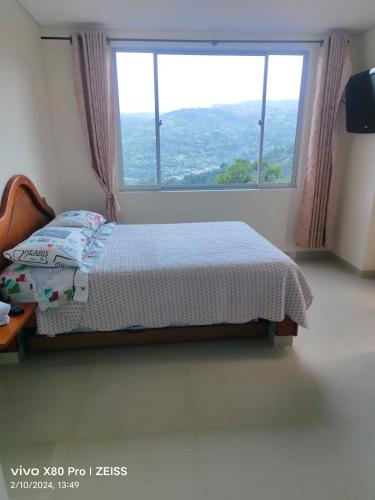 a bedroom with a bed and a large window at Hotel kristal campestre in San Francisco