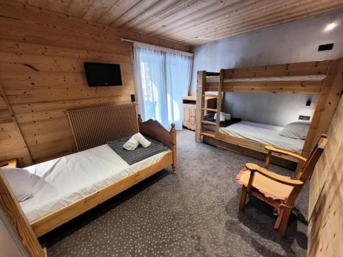 a bedroom with two bunk beds and a tv at Résidence Cry De Lys - Appartement entièrement rénové, au pied des pistes MAE-8431 in Les Gets