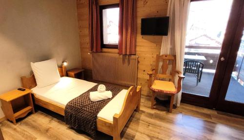 a bedroom with a bed and a tv and a window at Résidence Cry De Lys - Appartement entièrement rénové, au pied des pistes MAE-8441 in Les Gets