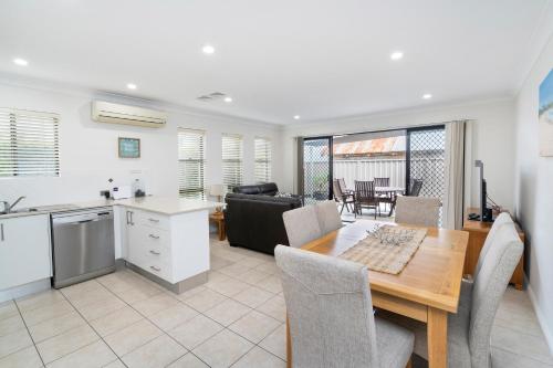 a kitchen and dining room with a table and a kitchen and a living room at LaBellaVita 26 Landsborough St SWR in South West Rocks