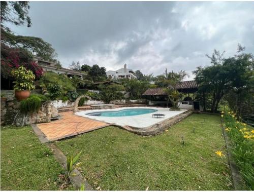 a backyard with a swimming pool and a house at DAPA CASA CAMPESTRE CON PISCINA y JACUZZI in Dapa