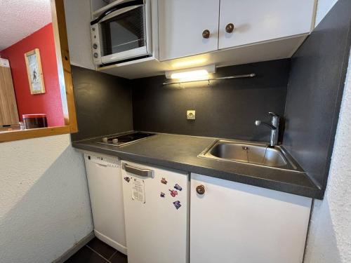 une petite cuisine avec un évier et un réfrigérateur dans l'établissement Studio rénové de 26 m² pour 4 pers avec balcon, accès pistes, animaux admis - Vallandry - FR-1-757-116, à Landry