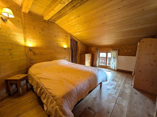 une chambre avec un lit dans une pièce en bois dans l'établissement Les Gets - Appartement de charme 3 chambres avec parking et WiFi - FR-1-623-360, aux Gets