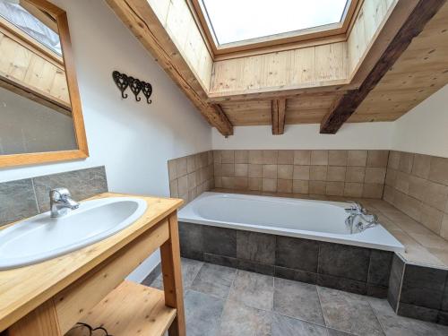 une salle de bain avec une baignoire et un lavabo dans l'établissement Les Gets - Appartement de charme 3 chambres avec parking et WiFi - FR-1-623-360, aux Gets