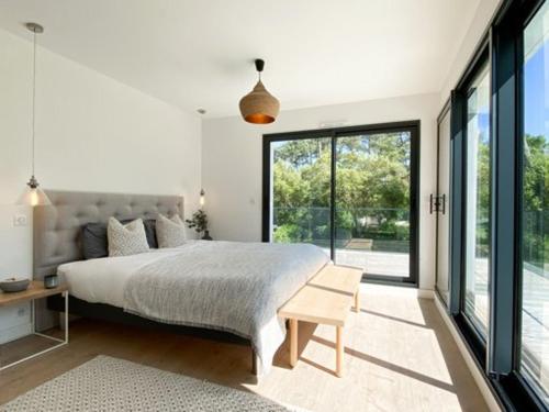 une chambre avec un lit et une grande fenêtre dans l'établissement Villa d'Exception avec Piscine et Jardin Proche Plages et Lac à Hossegor - FR-1-791-5, à Soorts-Hossegor