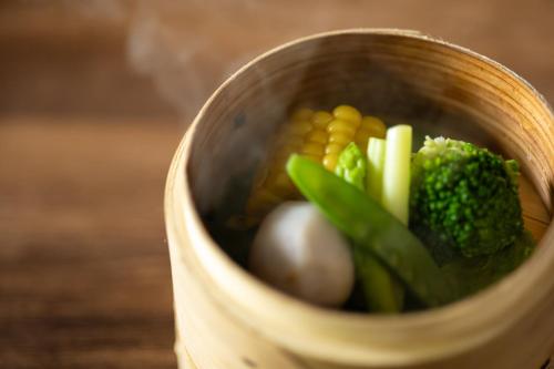 a wooden bowl filled with broccoli and other vegetables at NIPPONIA HARIMA FUKUSAKI ZOUSHONO YAKATA in Fukusaki