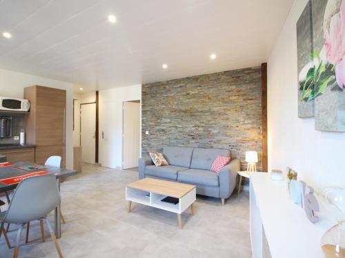 - un salon avec un canapé bleu et un mur en briques dans l'établissement Charmant T2 avec Wifi, proche thermes à La Bourboule - FR-1-608-272, à La Bourboule