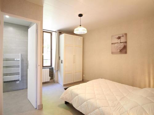 une chambre avec un lit blanc et une fenêtre dans l'établissement Charmant T2 avec Wifi, proche thermes à La Bourboule - FR-1-608-272, à La Bourboule