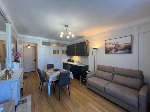 un salon avec un canapé et une table dans l'établissement Charmant studio au centre du Mont-Dore, bien équipé, max 2 pers - FR-1-608-273, à Mont-Dore