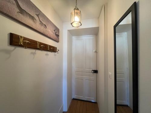 a hallway with a white door and a mirror at Charmant studio au centre du Mont-Dore, bien équipé, max 2 pers - FR-1-608-273 in Mont-Dore