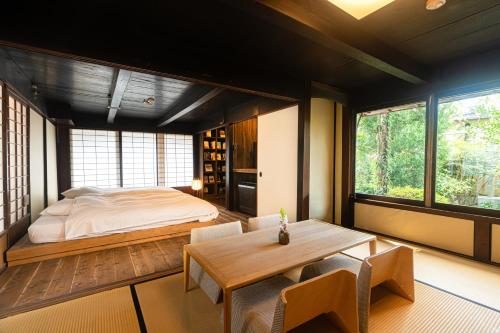 a bedroom with a bed and a table and chairs at NIPPONIA HARIMA FUKUSAKI ZOUSHONO YAKATA in Fukusaki