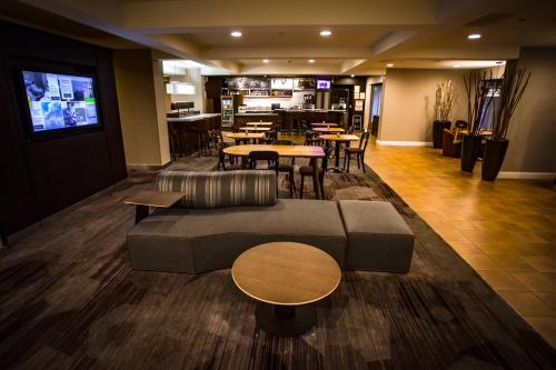 a lobby with a couch and tables and a restaurant at Courtyard Memphis East/Bill Morris Parkway in Memphis
