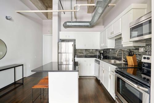 a kitchen with white cabinets and a black counter top at Reside Houston Downtown, a Wyndham Residence in Houston